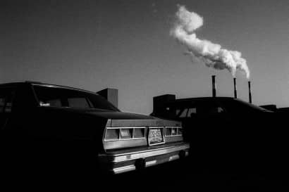 Cars on first plane, factories on the background